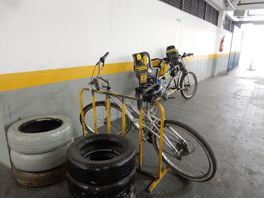 Bicicletário sem projeto de ambientação, com bicicletas e pneus junto à parede